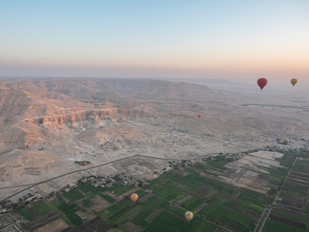 The Theban hills above the Luxor west bank at dawn, with hot-air balloons